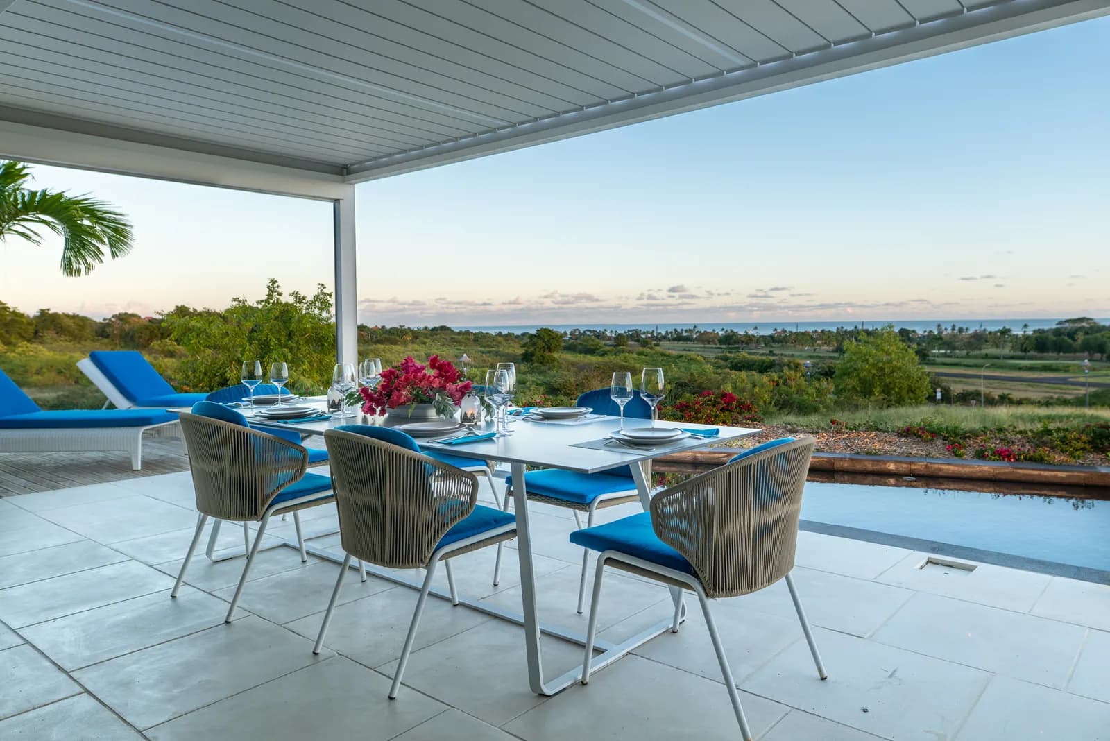 Art de vivre Belles Rives — terrasse couverte au coucher du soleil avec vue sur la végétation tropicale et l'océan